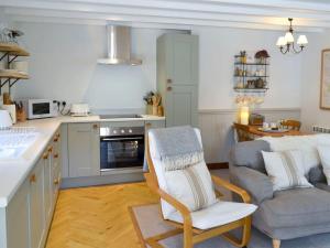 een keuken met een bank en een stoel in een kamer bij Wheatsheaf Cottage - 80021 in Sawdon