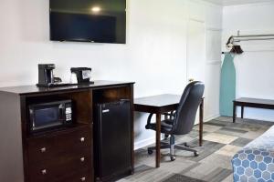 a hotel room with a desk and a chair at Rodeway Inn in Swainsboro