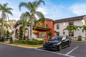 Clarion Pointe Tampa-Brandon Near Fairgrounds and Casino في تامبا: سيارة سوداء متوقفة في موقف للسيارات أمام منزل
