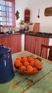 uma tigela de laranjas numa mesa numa cozinha em Casa Morango Gonçalves em Gonçalves