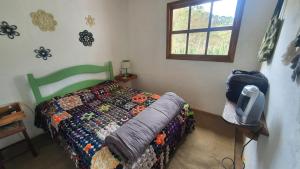a bedroom with a bed and a tv on a table at Casa Morango Gonçalves in Gonçalves