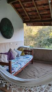 ein Bett in einer Hängematte auf einer Veranda in der Unterkunft Casa Morango Gonçalves in Gonçalves