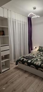 a bedroom with a bed and a window with curtains at D2 ASP - VIVO Mall in Floreşti