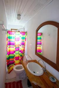 ein Badezimmer mit einem Waschbecken, einem WC und einem Spiegel in der Unterkunft Casa Morango Gonçalves in Gonçalves