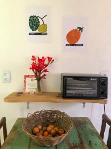Casa Morango Gonçalves في جونسالفيس: طاولة مع سلة من الفواكه وميكروويف
