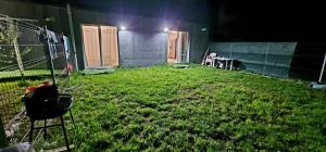 a backyard at night with a fence and green grass at D2 ASP - VIVO Mall in Floreşti