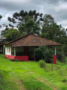 ein kleines Haus mit Rot und Weiß in der Unterkunft Casa Morango Gonçalves in Gonçalves