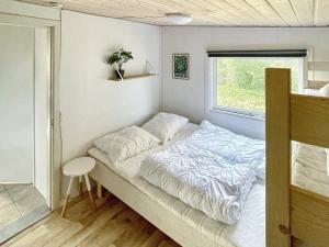 een kleine slaapkamer met een bed en een raam bij Holiday home Ørsted XXIII in Ørsted