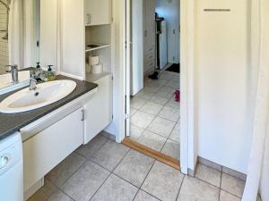 een witte badkamer met een wastafel en een spiegel bij Holiday home Ørsted XXIII in Ørsted