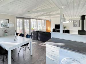 kuchnia i salon ze stołem i krzesłami w obiekcie Holiday home Ørsted XXIII w mieście Ørsted