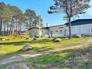 a building with rocks in the grass in front of it at 7 person holiday home in Gilleleje-By Traum in Gilleleje