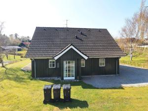 a small house with two parking meters in front of it at 8 person holiday home in L gstrup in Hjarbæk