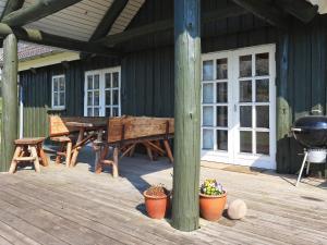 a wooden deck with a picnic table and a grill at 8 person holiday home in L gstrup in Hjarbæk