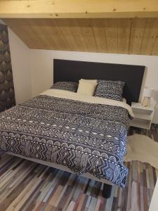 a bedroom with a bed with a black and white comforter at La maison blanche in Limoges