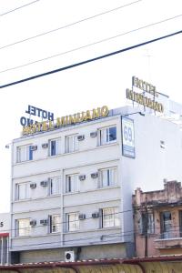 a large building with a sign on top of it at Minuano Hotel Home próximo ao aeroporto in Porto Alegre
