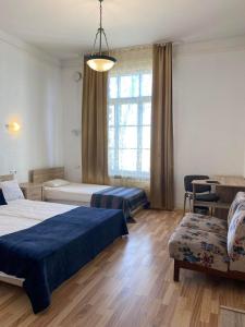 1 dormitorio con 2 camas, silla y ventana en Aquamarine Hotel - Lauluväljak en Tallin