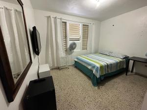 Rúm í herbergi á Mayagüez Unit 2, 5BR, 2BA Sleeps Up to 12