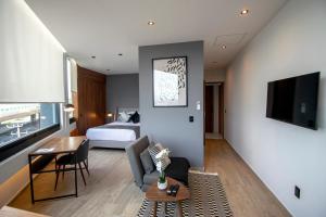 una sala de estar con una habitación con una cama y una mesa en Punto Lofts Periférico Sur, en Ciudad de México