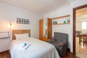1 dormitorio con 1 cama grande y 1 silla en Magdalena - baskeyrentals en Ondárroa