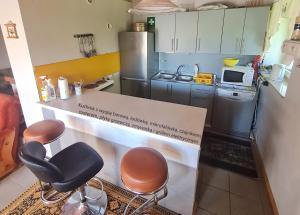 eine Küche mit einer Theke mit zwei Stühlen und einer Arbeitsplatte in der Unterkunft Domek letniskowy w Szkotowie in Szkotowo