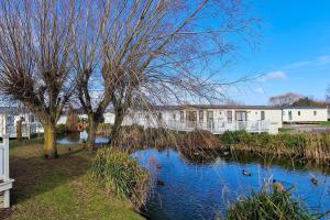 a body of water with ducks swimming in it at Stunning 6 Berth Lodge With Decking At Manor Park In Hunstanton Ref 23064k in Hunstanton