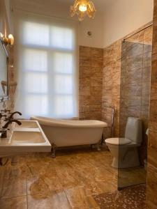 uma casa de banho com uma banheira, um WC e um lavatório. em Aquamarine Hotel - Lauluväljak em Talin