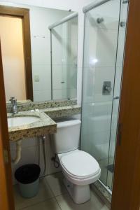 a bathroom with a toilet a sink and a shower at Minuano Hotel Home próximo ao aeroporto in Porto Alegre