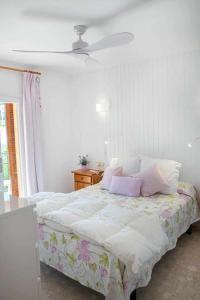 a bedroom with a bed with pink pillows on it at Apartamento vista mar en SAgaró a 100m playa in Sant Feliu de Guixols