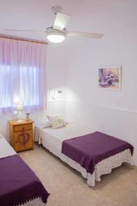 a bedroom with two beds with purple sheets and a window at Apartamento vista mar en SAgaró a 100m playa in Sant Feliu de Guixols