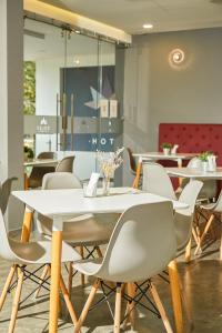 une salle à manger avec une table et des chaises blanches dans l'établissement Solev Hotel, à Villavicencio