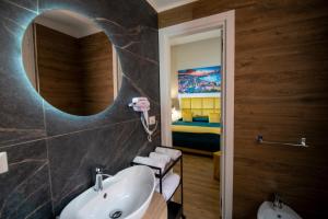 1 dormitorio y baño con lavabo y espejo. en VIVI A NAPOLI en Nápoles