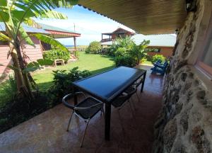 a black table and chairs on a patio at Cabañas Christophe in Hanga Roa