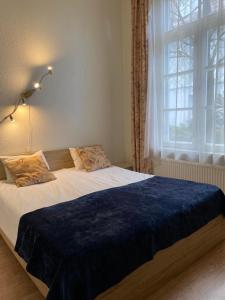 a bedroom with a large bed with a blue blanket at Aquamarine Hotel - Lauluväljak in Tallinn