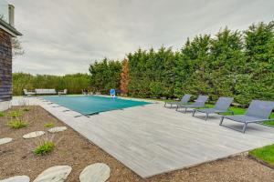eine Terrasse mit Stühlen und einem Pool in der Unterkunft Stunning Westhampton Beach Home with Private Pool in Westhampton Beach