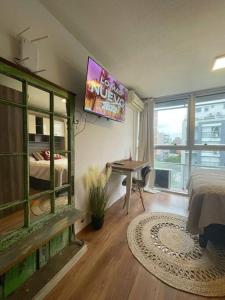 Habitación con cama y TV en la pared. en Mono en piso 8 - Punta Carretas en Montevideo