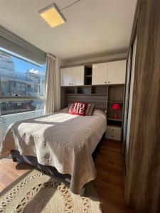 1 dormitorio con cama y ventana grande en Mono en piso 8 - Punta Carretas en Montevideo