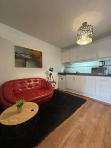 sala de estar con sofá rojo y mesa en Mono en piso 8 - Punta Carretas, en Montevideo