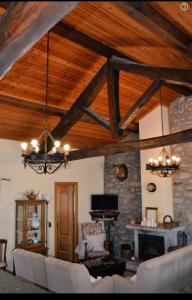 una sala de estar con techos de madera y una chimenea de piedra. en Casa Rural El Corredor en Cabornera de Gordón en Cabornera