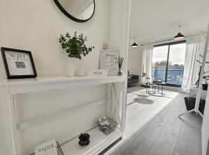 a white fireplace in a living room with a mirror at The Madison Apartment by TTLG Stays in Hemel Hempstead