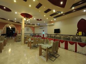 a restaurant with tables and chairs and a bar at Bahla Hotel Apartments in Bahlāʼ
