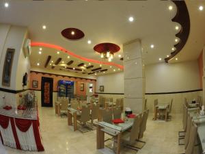 a dining room with tables and chairs in a restaurant at Bahla Hotel Apartments in Bahlāʼ