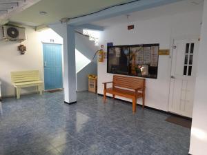 um quarto com um banco e uma televisão na parede em Posada Henry Sede Centro em San Andrés