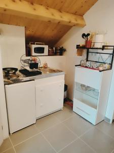 uma cozinha com armários brancos e um frigorífico branco em La maison blanche em Limoges