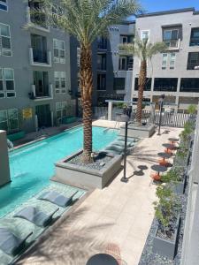 a swimming pool with chairs and palm trees in a building at Luxury Apartment in Downtown Las Vegas in Las Vegas