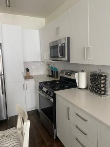 a kitchen with white cabinets and a black stove top oven at Luxury Apartment in Downtown Las Vegas in Las Vegas