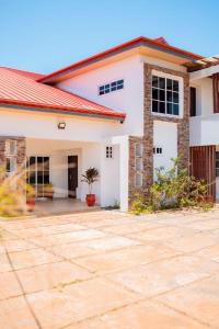 a house with a red roof at Lovely 4 Bedroom Solar Powered House with CCTV and Unlimited WiFi near Devtraco Court Community 25 Tema in Tema