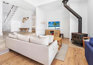 un soggiorno con divano bianco e stufa a legna. di Hamptons Escape a Gerroa
