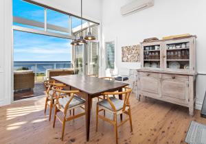 una sala da pranzo con tavolo, sedie e finestra di Hamptons Escape a Gerroa