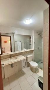 ein Bad mit einem WC, einem Waschbecken und einer Dusche in der Unterkunft Beira Mar e Sossego C13 Praia de Zumbi RN in Zumbi