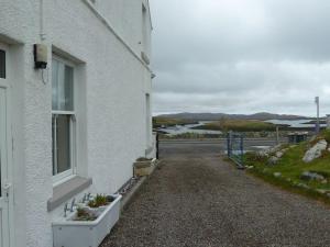 a white building with a window with plants on it at The Studio in Lochmaddy